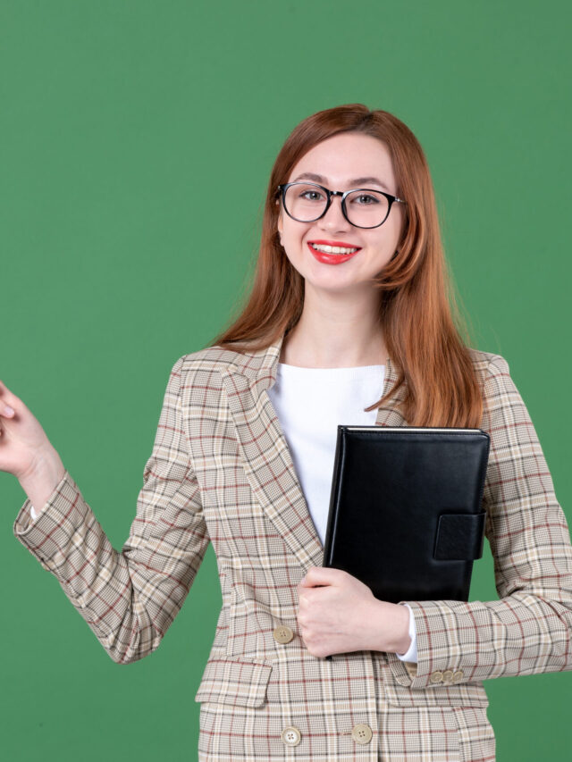 portrait-female-teacher-holding-notepad-green